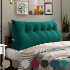 a bed with a blue tufted headboard and colorful circles on the wall above it