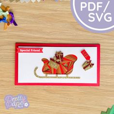 a red and gold card with a paper mouse on it, next to some streamers