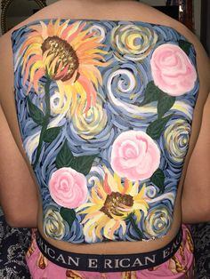 the back of a woman's top with flowers painted on it