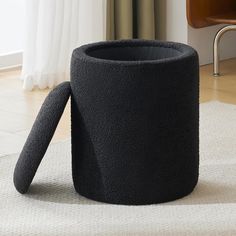 a black coffee cup sitting on top of a rug