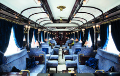 the inside of a train car with blue velvet seats