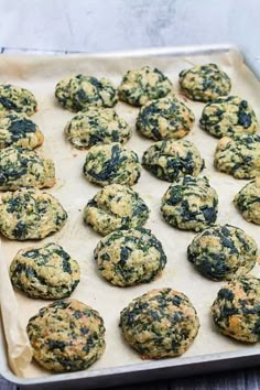 a baking sheet filled with cookies on top of a wooden table