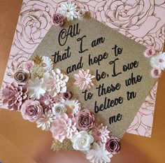 a graduation cap decorated with flowers on top of a card that says, call that i am and hope to be i love to those who believe in me