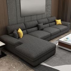 a living room with a large gray couch and yellow pillows on the back of it