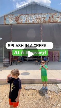 two young boys standing in front of a building with a sign that says splash in a creek