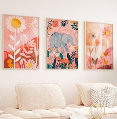 three paintings hang on the wall above a couch in a room with white furniture and pillows