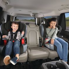 two children sitting in the back of a vehicle