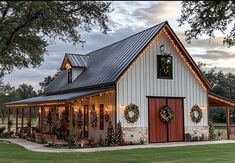 a white barn with christmas lights and wreaths on it