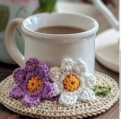 there is a coffee cup with crocheted flowers on it