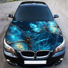 a black car with blue butterflies painted on it