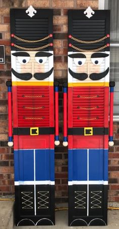 two large wooden nutcrackers sitting next to each other in front of a brick wall