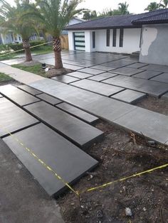 a concrete patio being laid out in front of a house with yellow tape on the ground