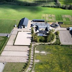 an aerial view of a large farm with lots of grass and trees in the background