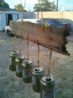 some cans are hanging from a wooden plank