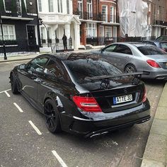 a black car parked on the side of a street