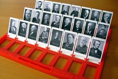 a red rack with photos of men in black and white on it sitting on a wooden table