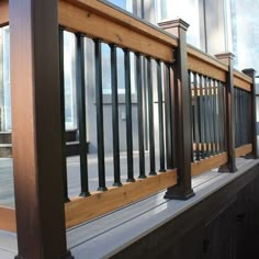 a wooden balcony with metal railings and windows