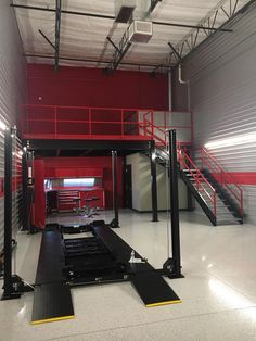 the inside of a storage building with stairs and treadmills on each side of the door