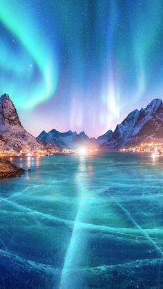 an aurora bore over the mountains and water with lights in the sky at night time