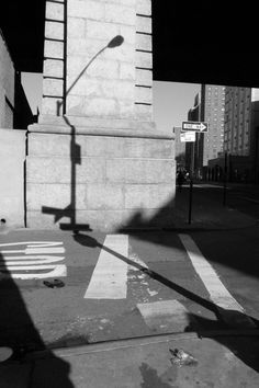 the shadow of a street sign is cast on the sidewalk