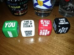 four dices that are sitting on a table next to a glass with alcohol in it