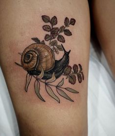 a snail with leaves and flowers on the thigh