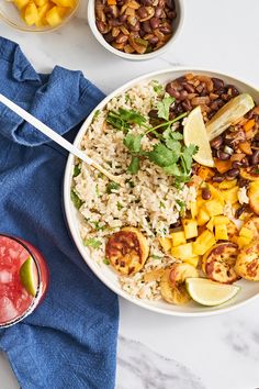 a bowl filled with rice and beans next to two bowls of fruit, watermelon and pineapple slices