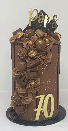 a cake with chocolate frosting and gold decorations on it's top is shown