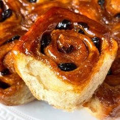 cinnamon rolls with raisins on a white plate