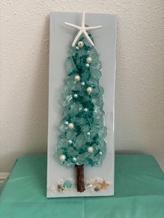 a glass christmas tree with starfish on top