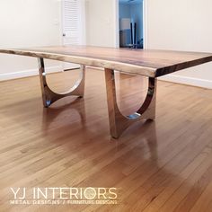 a large wooden table sitting on top of a hard wood flooring covered floor next to a doorway