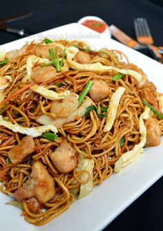 a white plate topped with noodles and shrimp