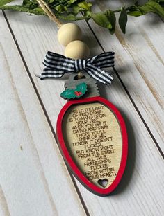 an ornament with a wooden frame and ribbon hanging from it's side