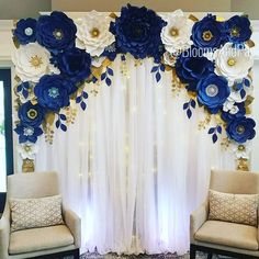 two chairs sitting in front of a blue and white floral backdrop with gold accents on it