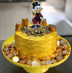 a yellow cake with coins and a cartoon character on top