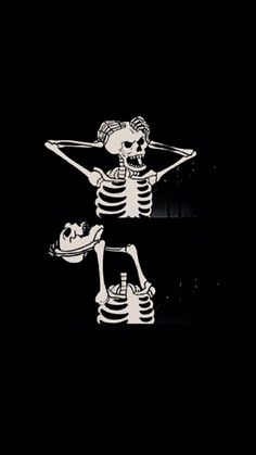 two skeleton stickers sitting on top of each other in the dark, with one holding a