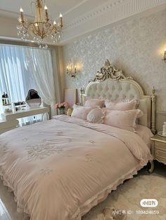 a large bed sitting in a bedroom next to a window with chandelier above it