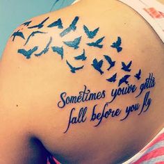 the back of a woman's shoulder with birds on it and some words written in blue ink