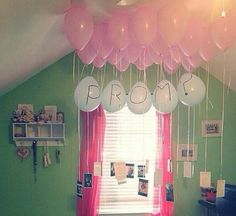 some balloons are hanging from the ceiling in a room with green walls and pink curtains