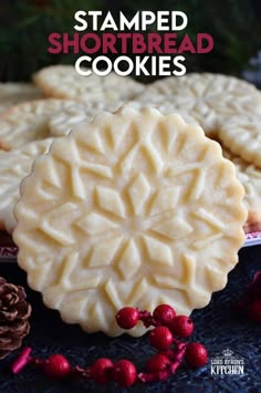 some cookies are sitting on a table next to pine cones and cranberry berries