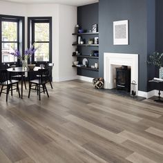 a living room filled with furniture and a fire place next to a dining room table