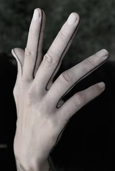 a person's hand with their fingers extended out to the side, in black and white