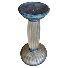 a glass pedestal with a candle on top