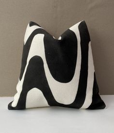 a black and white pillow sitting on top of a table