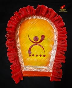 a red and yellow decorative object with a person on it's face in the center