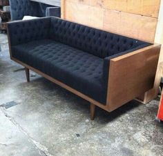 a black couch sitting on top of a wooden floor