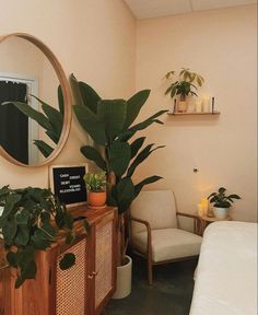 a bedroom with a bed, mirror and plants