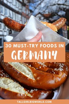 a person holding a bagel with the words 30 must try foods in germany