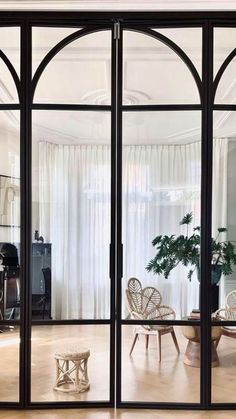 a living room filled with furniture and lots of glass doors that look out onto the outside