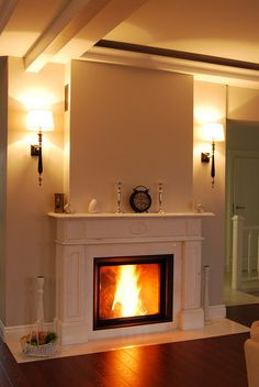 a fire place in the middle of a room with two lamps on either side of it